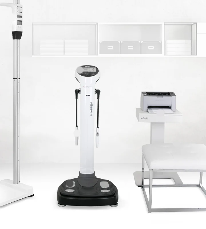 InBody 570 body composition analyzer set up in a clinic testing room with a stadiometer for height and the results printer